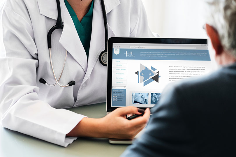 Doctor showing laptop image to a person wearing a black shirt.