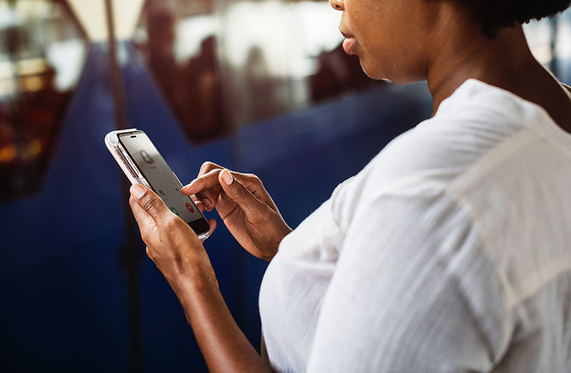 Young black woman checks her mobile phone. 