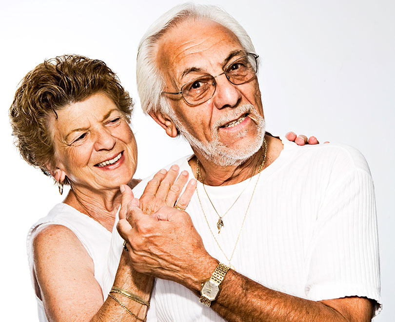 Mature couple smiling, in an embrace.