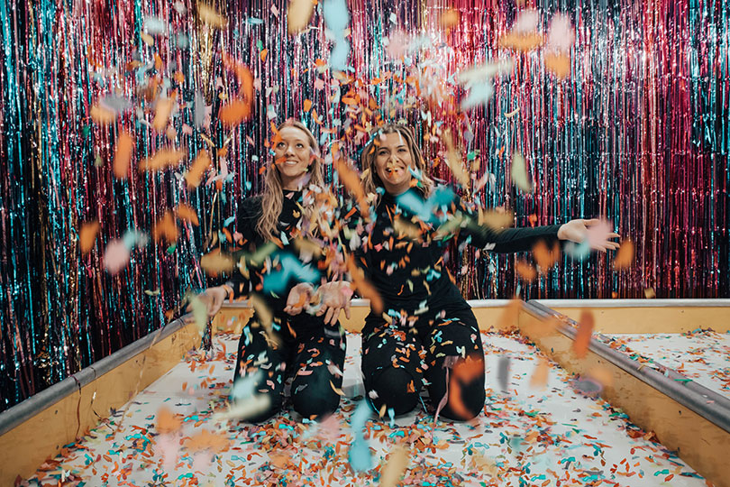 Two women having fun with confetti.