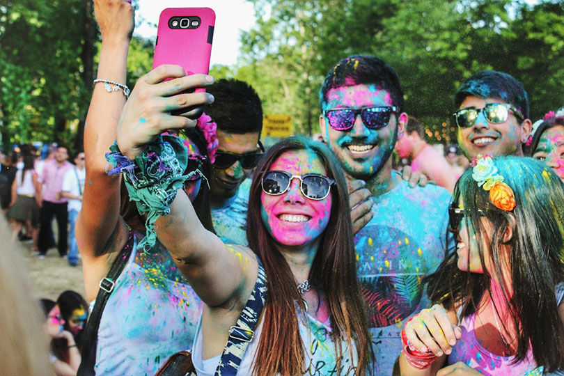 Group of young people taking a selfie at a color run race.