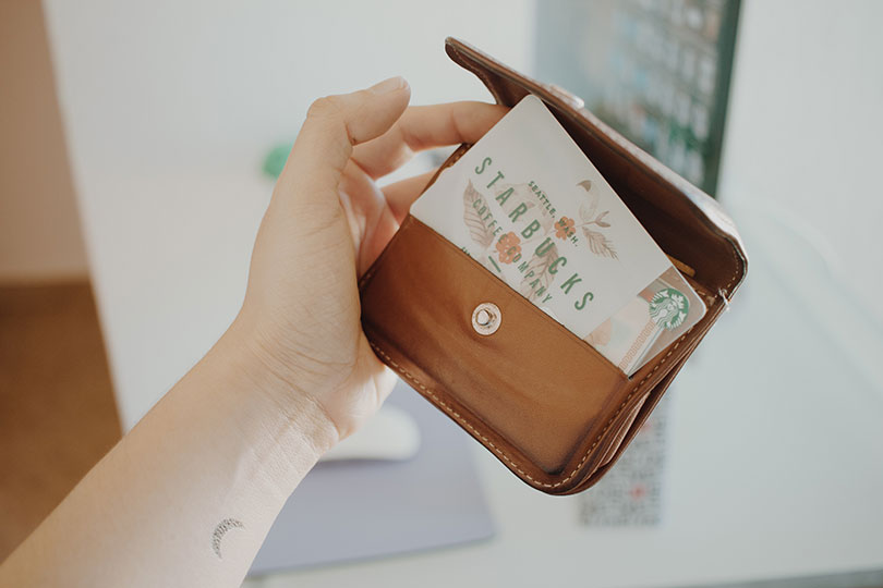 Hand holding a wallet with a loyalty card.