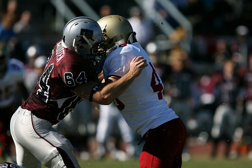 Football players battle for position.