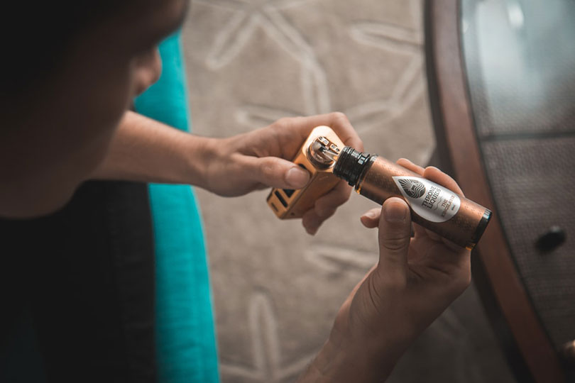 Person putting liquid into a vaporizer.