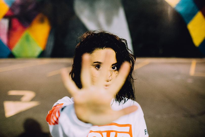 Woman with her hand raised indicating to stop.