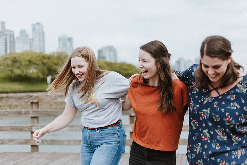 Three young women walking outdoors together.