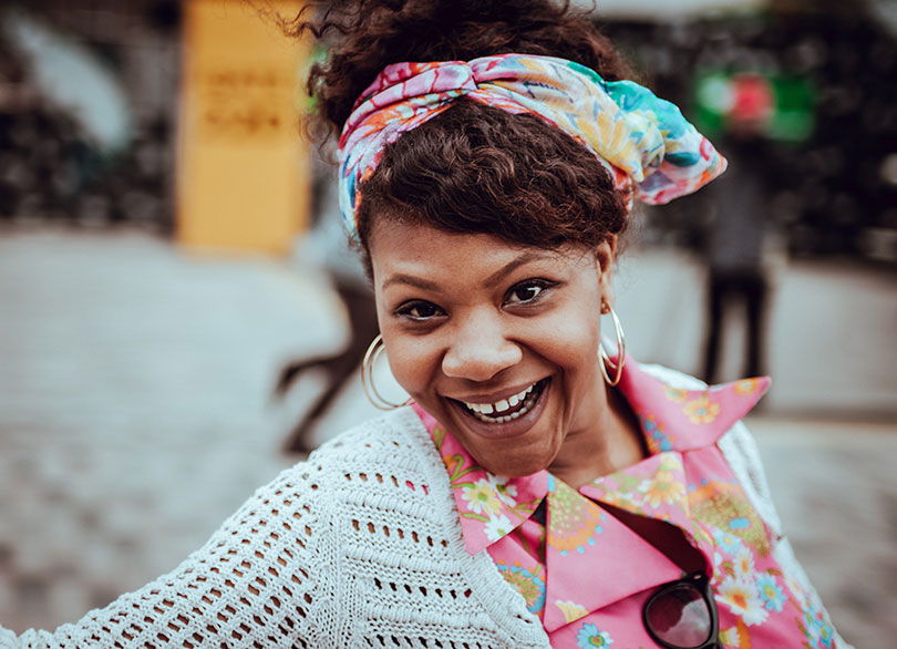 A woman smiling broadly while outdoors