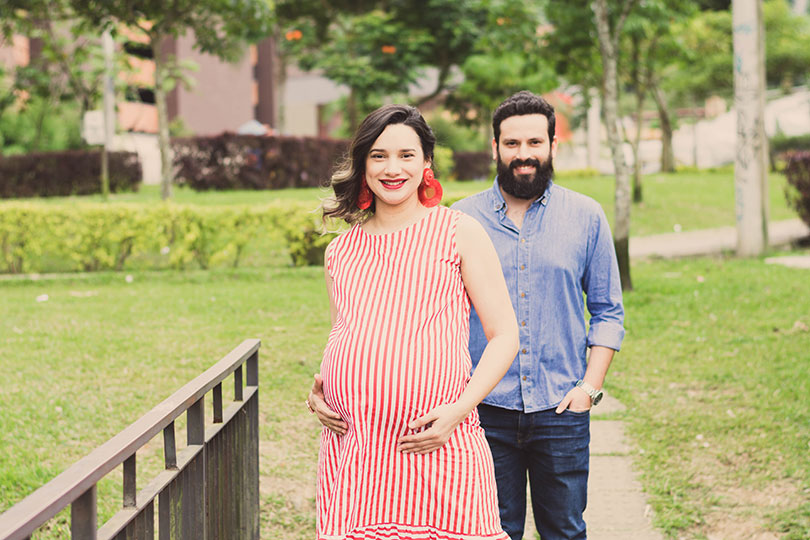 Smiling pregnant woman with man in foreground 