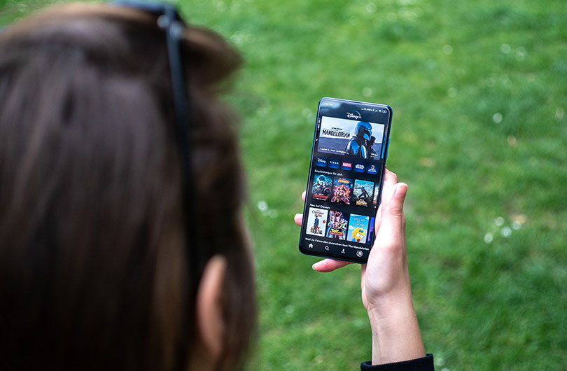 Woman scrolling through TV shows on a mobile device